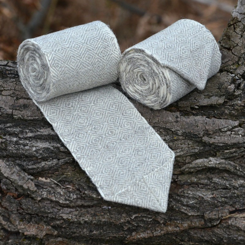 A pair of leg wraps, made from wool in a diamond pattern. Natural shades of sheep's wool were used for the weaving.