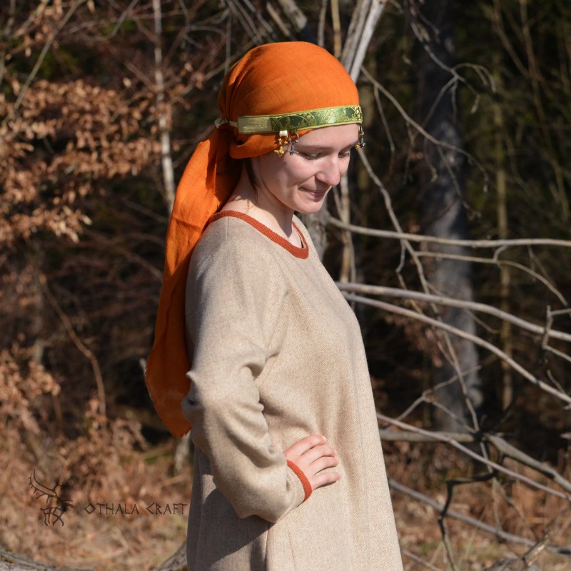 The headband is made of linen in burgundy, decorated with layer woven in a pattern of ancient silk. Earflaps on the sides.