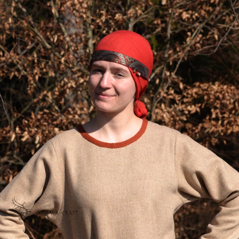 The headband is made of linen in burgundy, decorated with layer woven in a pattern of ancient silk. Earflaps on the sides.
