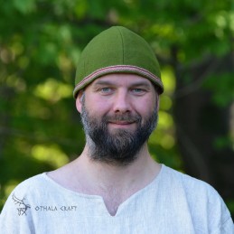 Simple hat made of green wool in diagonal pattern. Hat has six wedges.