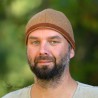 Simple hat made of beige wool, bordered with green and orange herringbone wool.